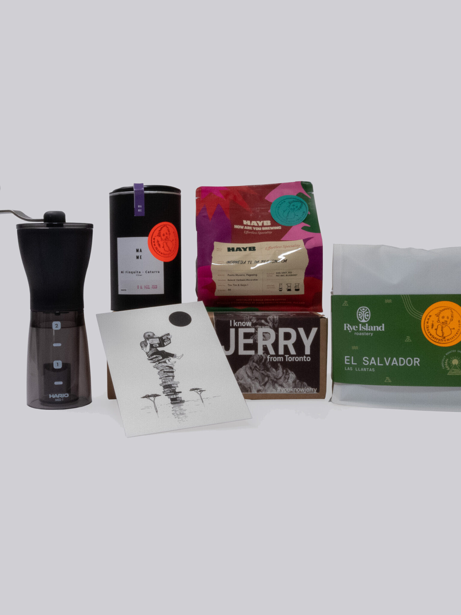 Packshot of the Grinder Box with coffee from Hayb, Rye Island, Mame and an artwork of Gijs Vanhee and a grinder from Hario
